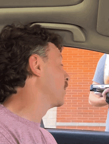 Man with a mustache in a car giving a long side-eye