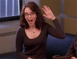 Tina Fey as Liz Lemon waving excitedly then awkwardly