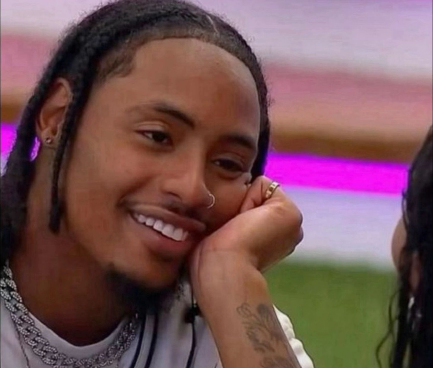 Guy resting his chin on his hand with a smooth, flirtatious smile