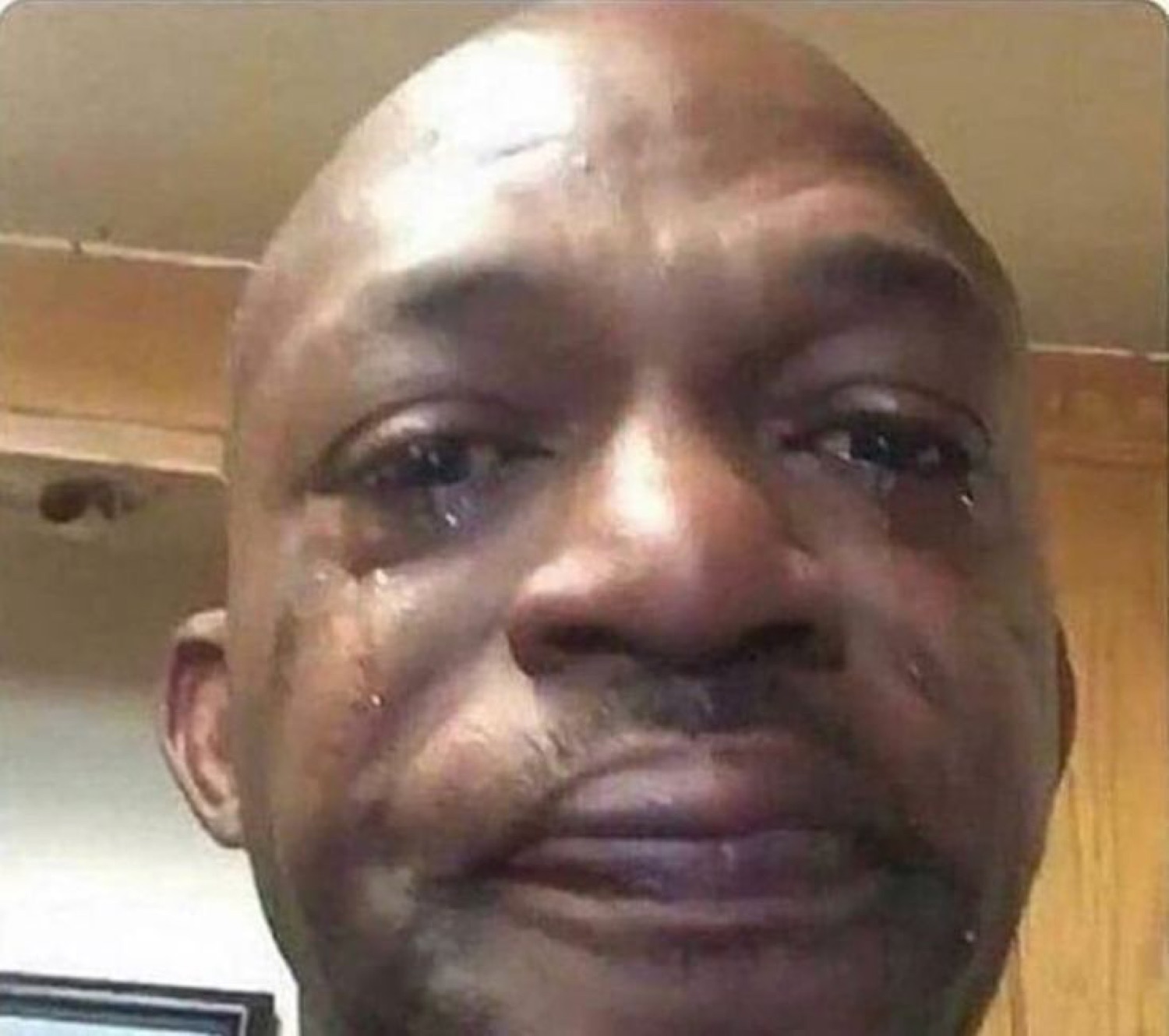 Man with tears streaming down his face holding back an emotional, sad expression