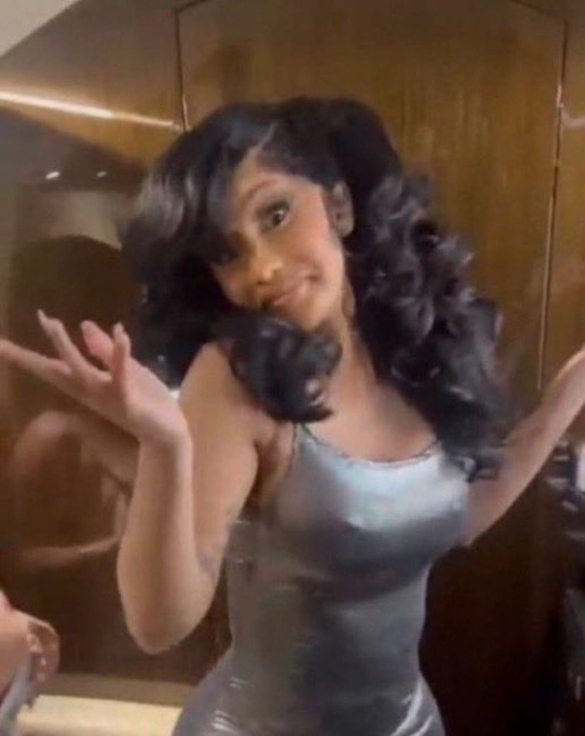 Woman in a silver dress with curly pigtails posing with a smug little smirk