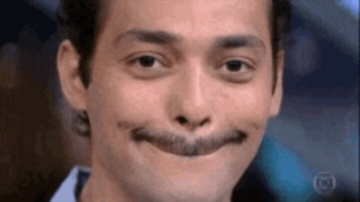Man with a curled mustache holding back a smug, tight-lipped smirk