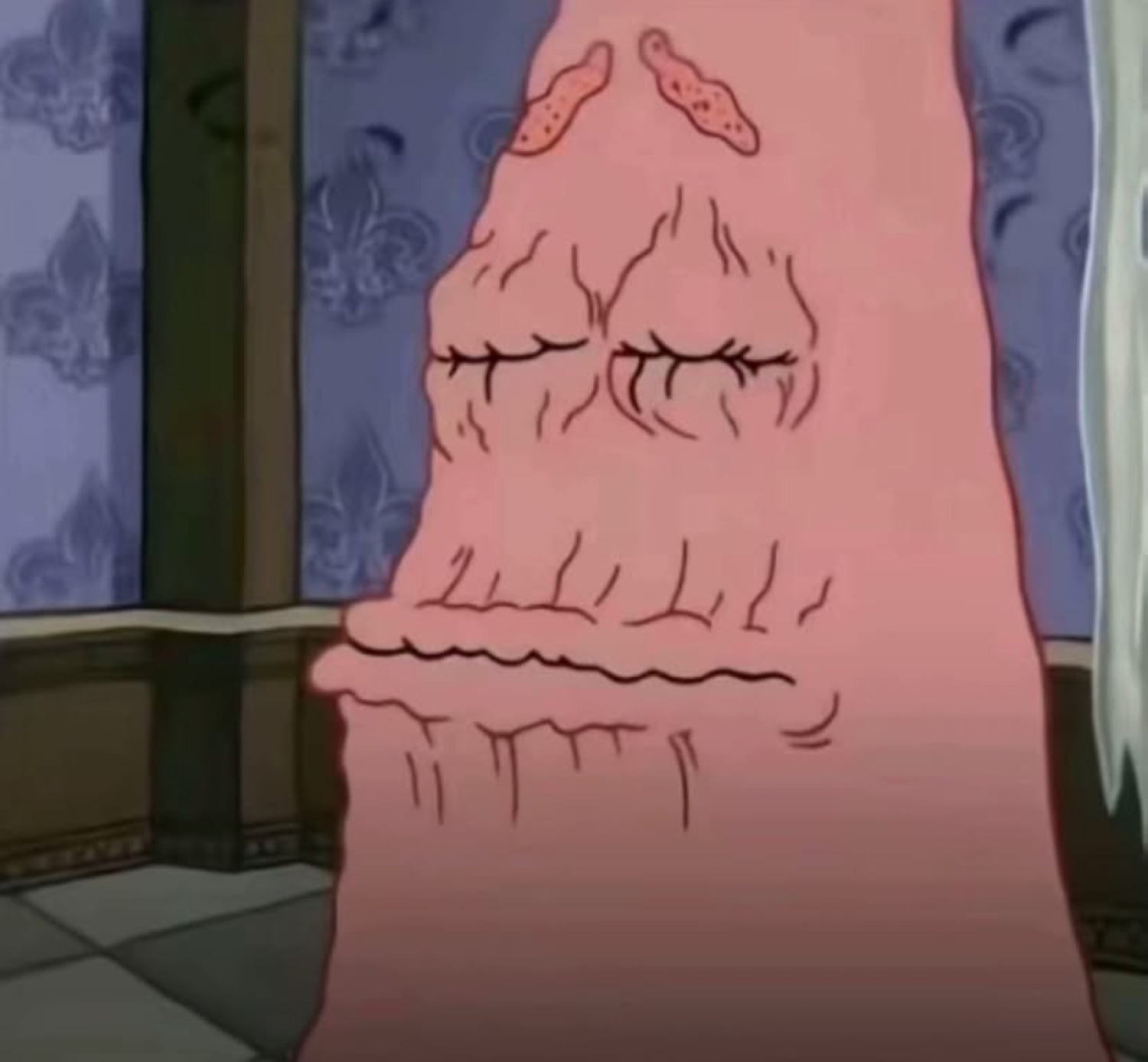 Extreme close-up of a wrinkled pink cartoon face with its eyes shut