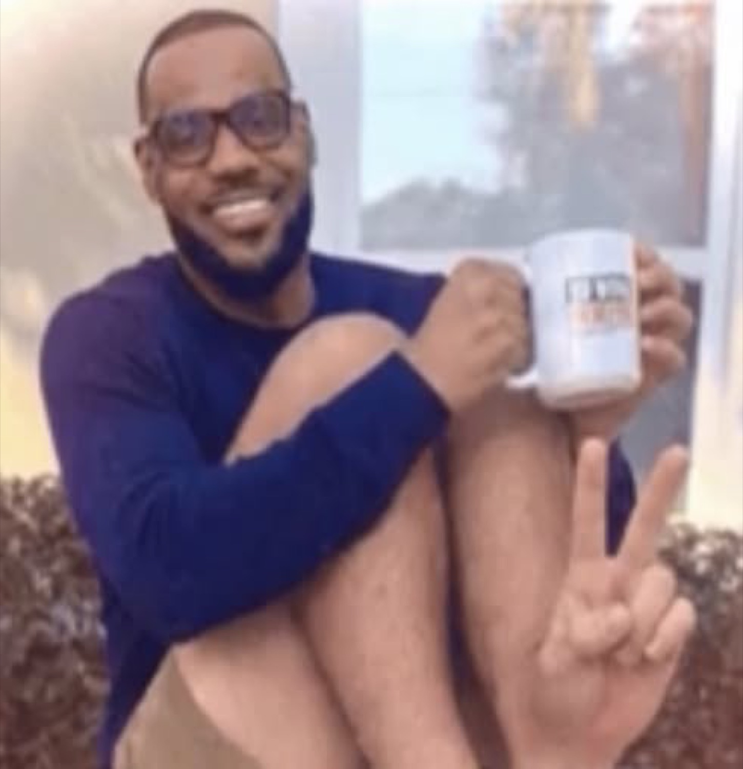 LeBron throwing a peace sign with a mug