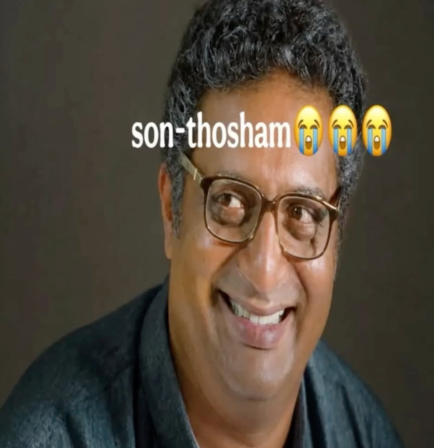 Prakash Raj grinning through glasses: 'son-thosham😭😭😭' (happiness)