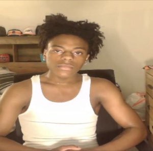 Young guy in a white tank top giving a flat, unamused deadpan stare