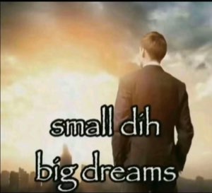 Suited man gazing at a glowing city skyline captioned 'small dih big dreams'