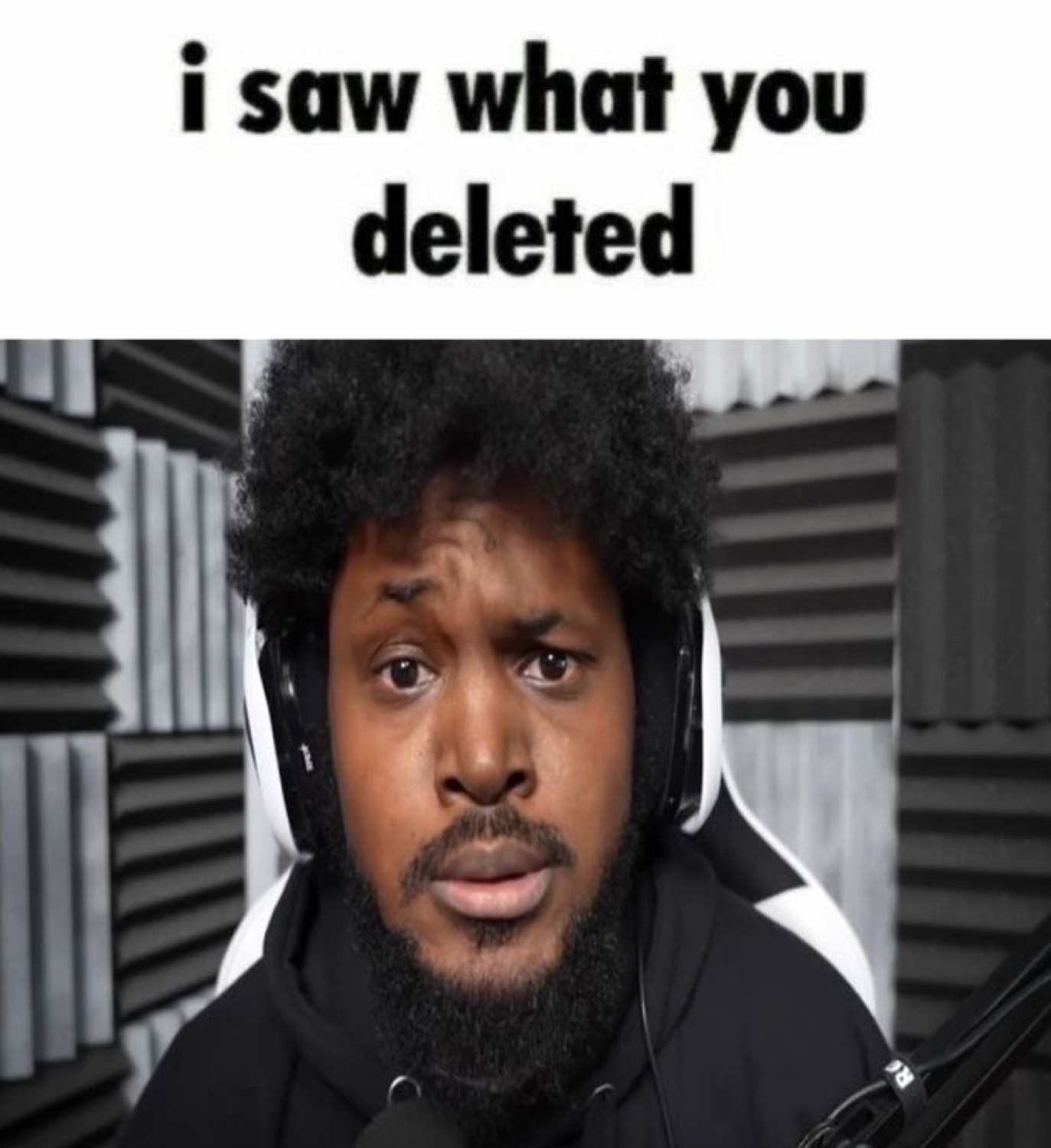 Man in a gaming headset staring flatly at the camera captioned 'i saw what you deleted'
