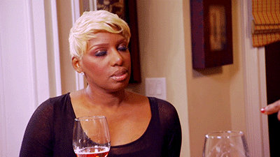 NeNe Leakes holding a wine glass and delivering a slow, unimpressed side-glance