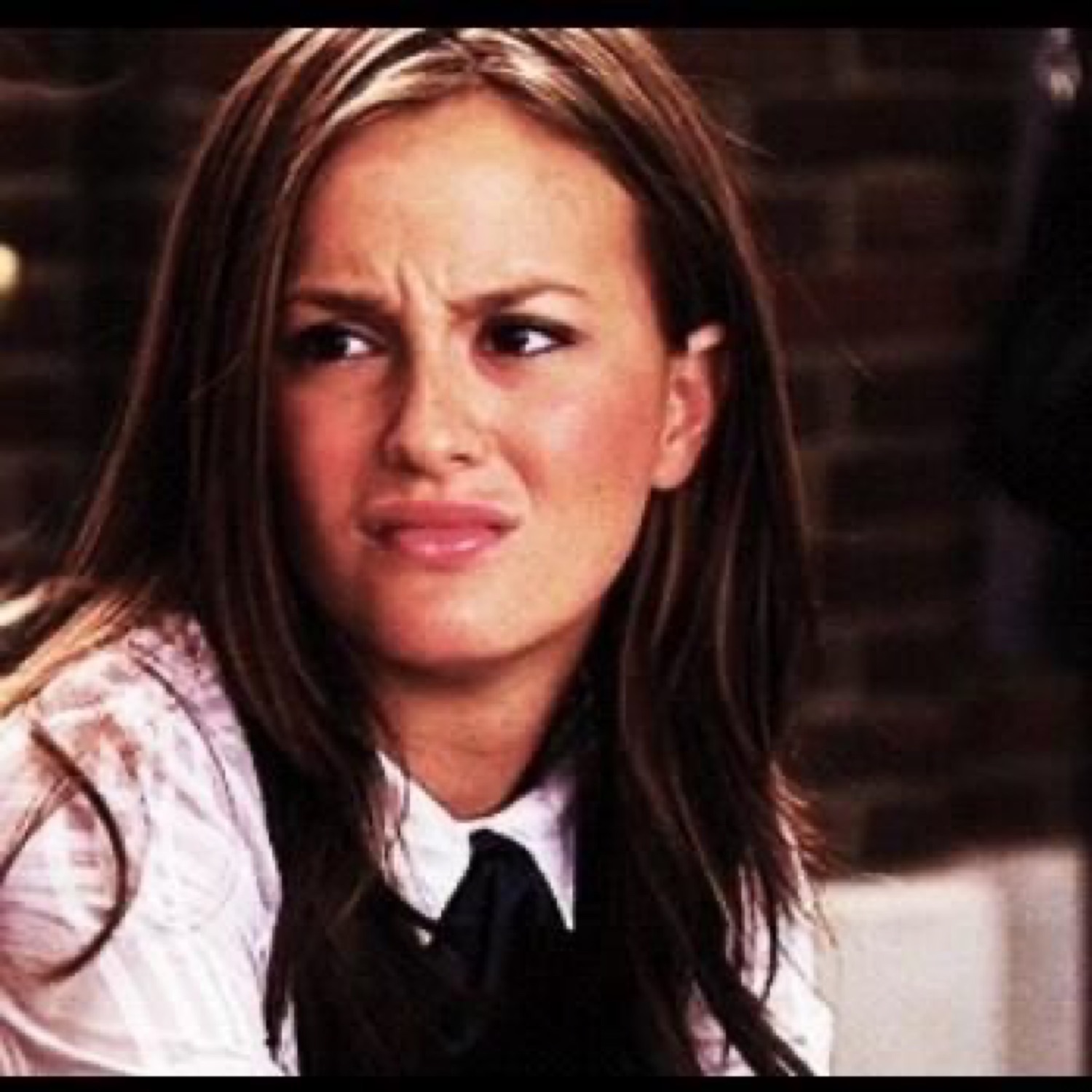 Woman scrunching her face into a disgusted, unimpressed grimace
