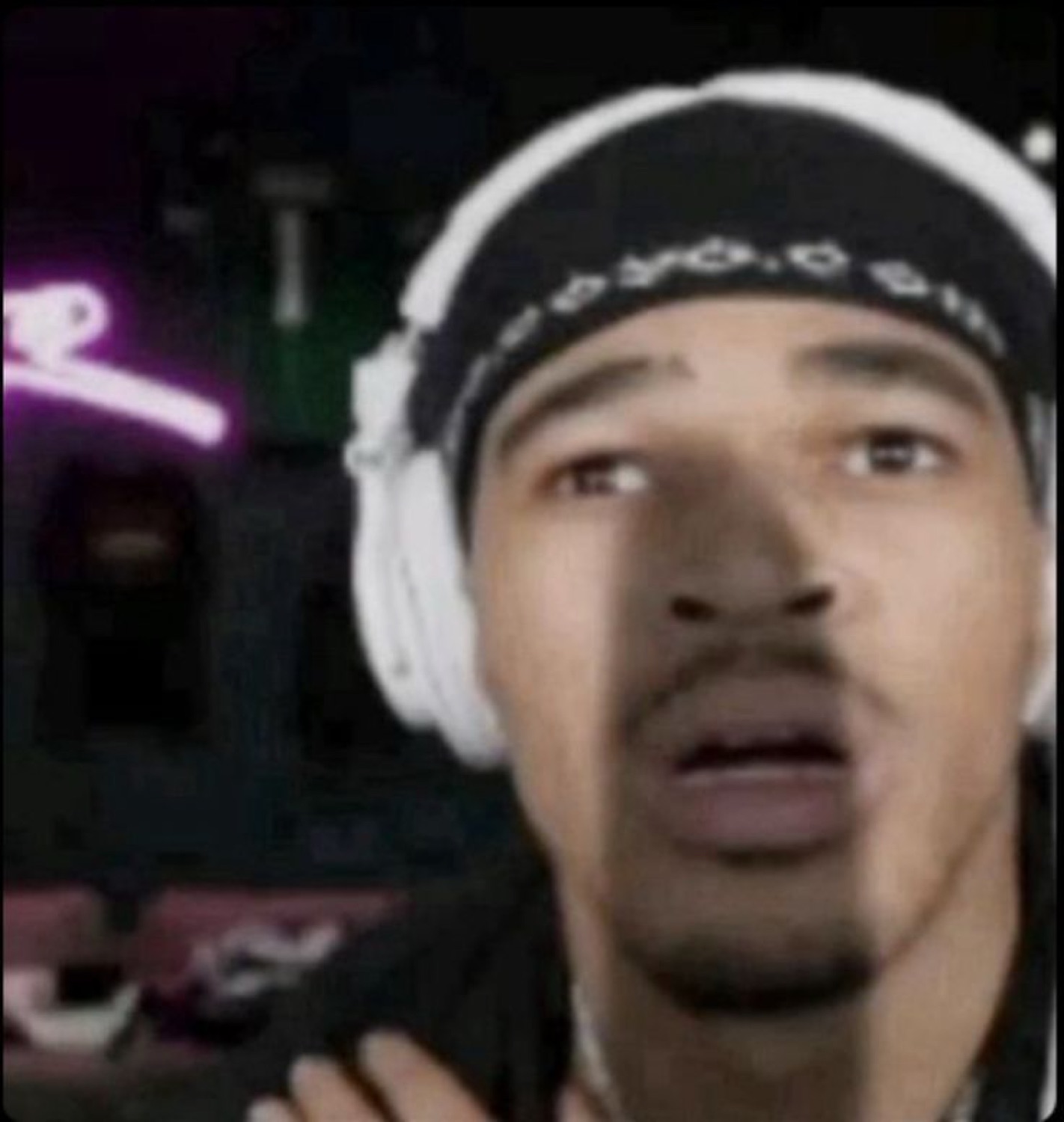 Guy with headphones and a bandana staring blankly with mouth slightly open mid-stream