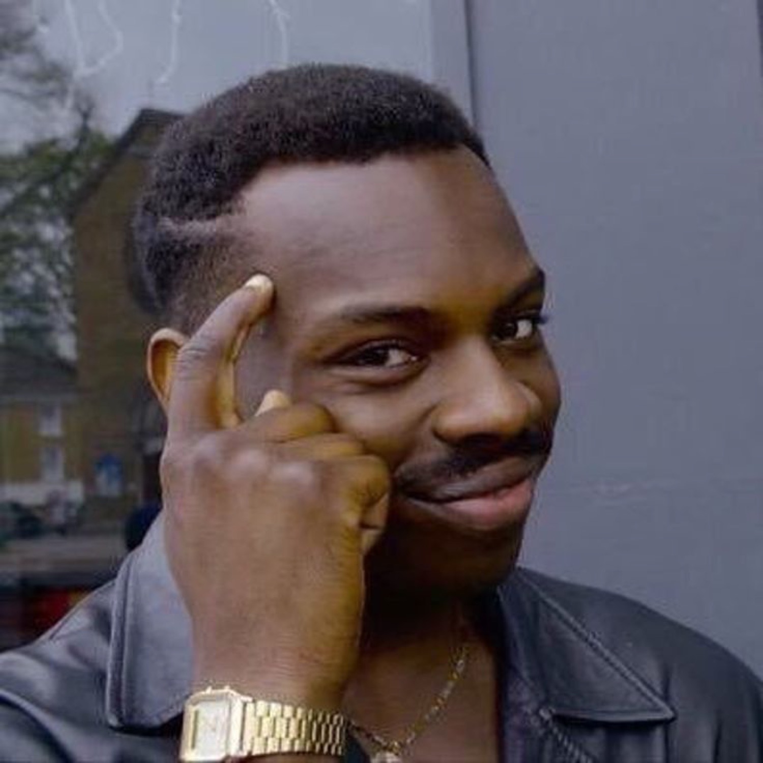 A man tapping his temple with a knowing smirk, like he just outsmarted everyone