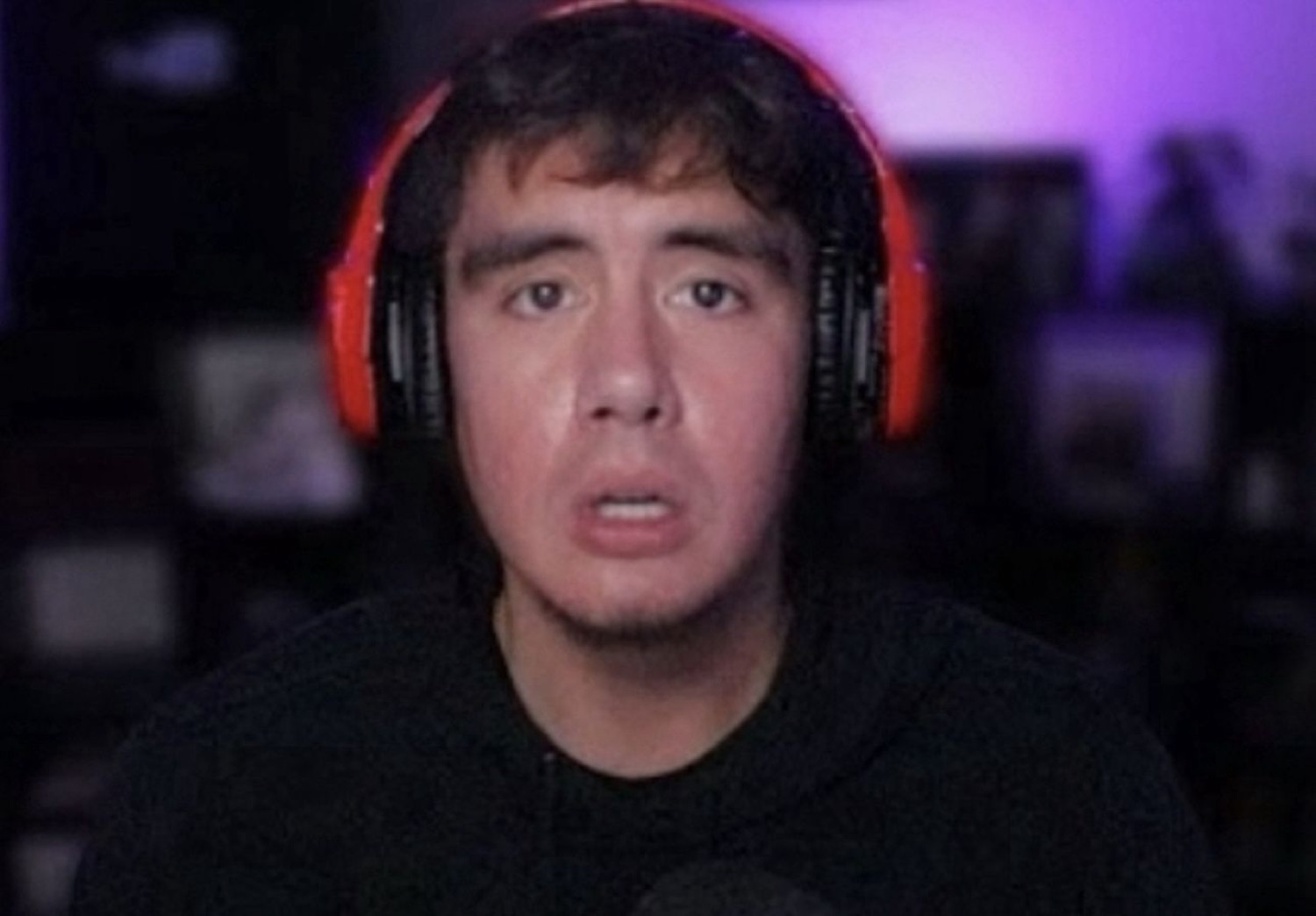 Gamer in red headphones staring at the screen with a slack-jawed, baffled expression
