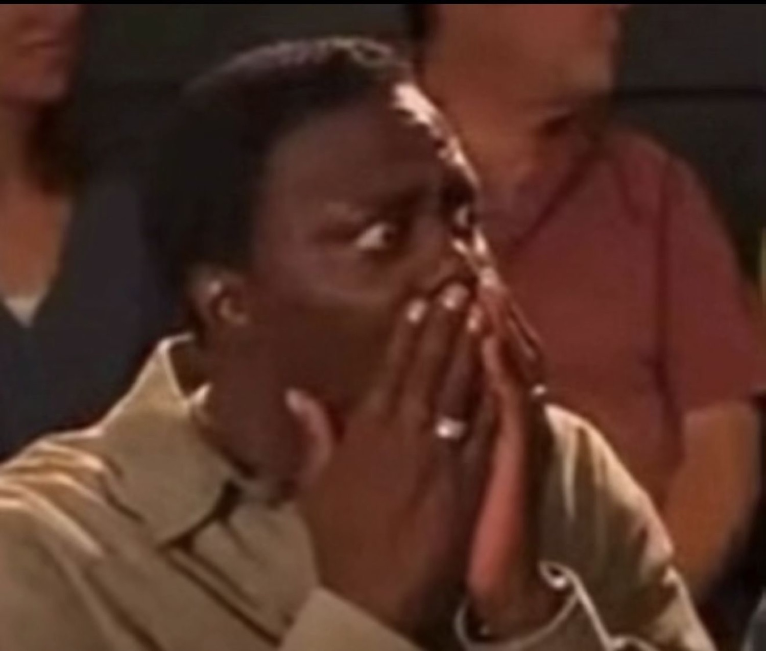 Audience member covering their mouth in stunned disbelief at something they just witnessed