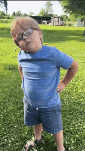 Boy in glasses with hands on his hips letting out a big sigh