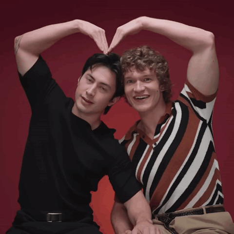 shane and ilya (hudson williams and connor storrie) men making a heart shape with their arms together
