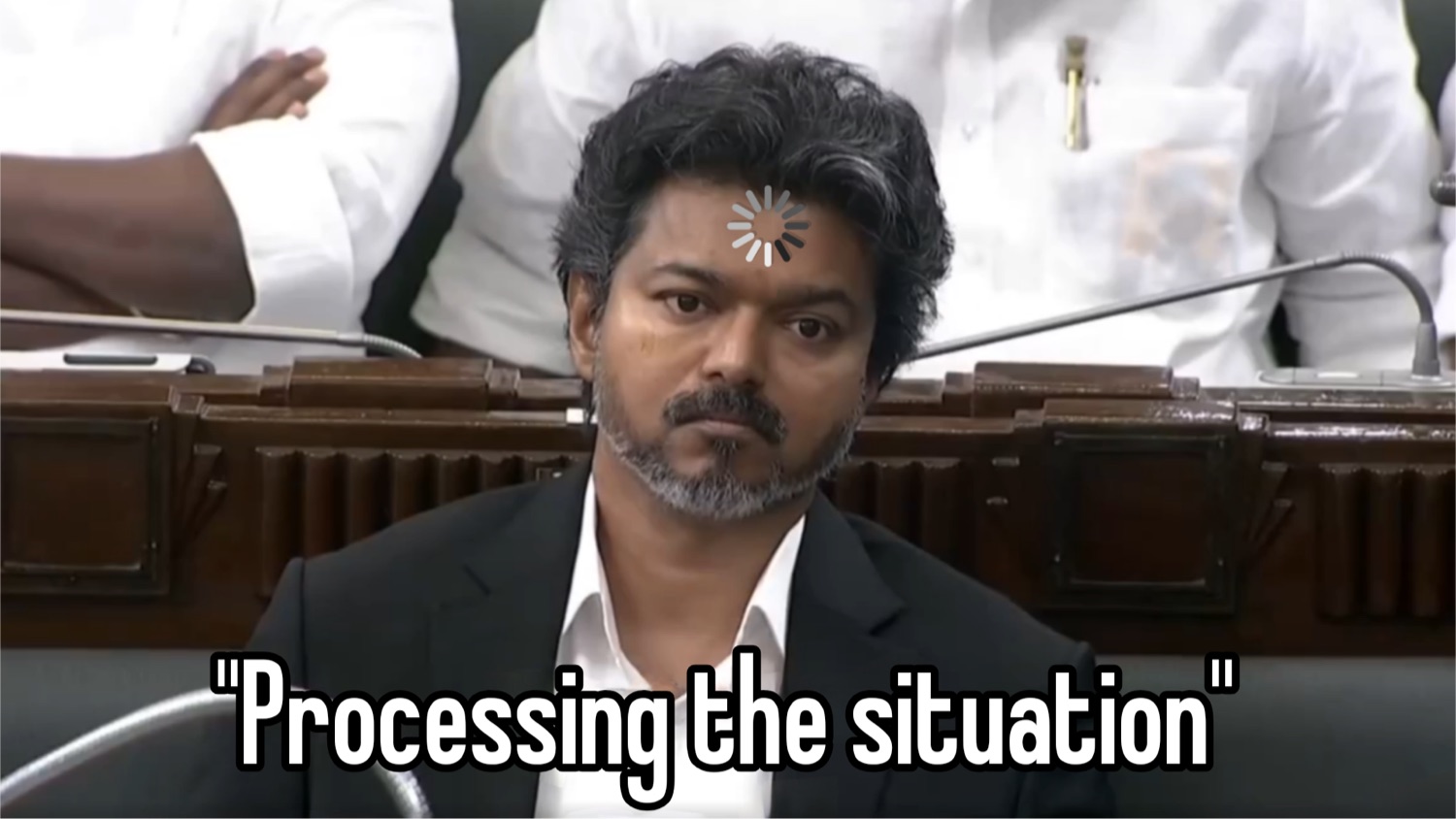 Vijay in a suit with a loading spinner on his head: '"Processing the situation"'