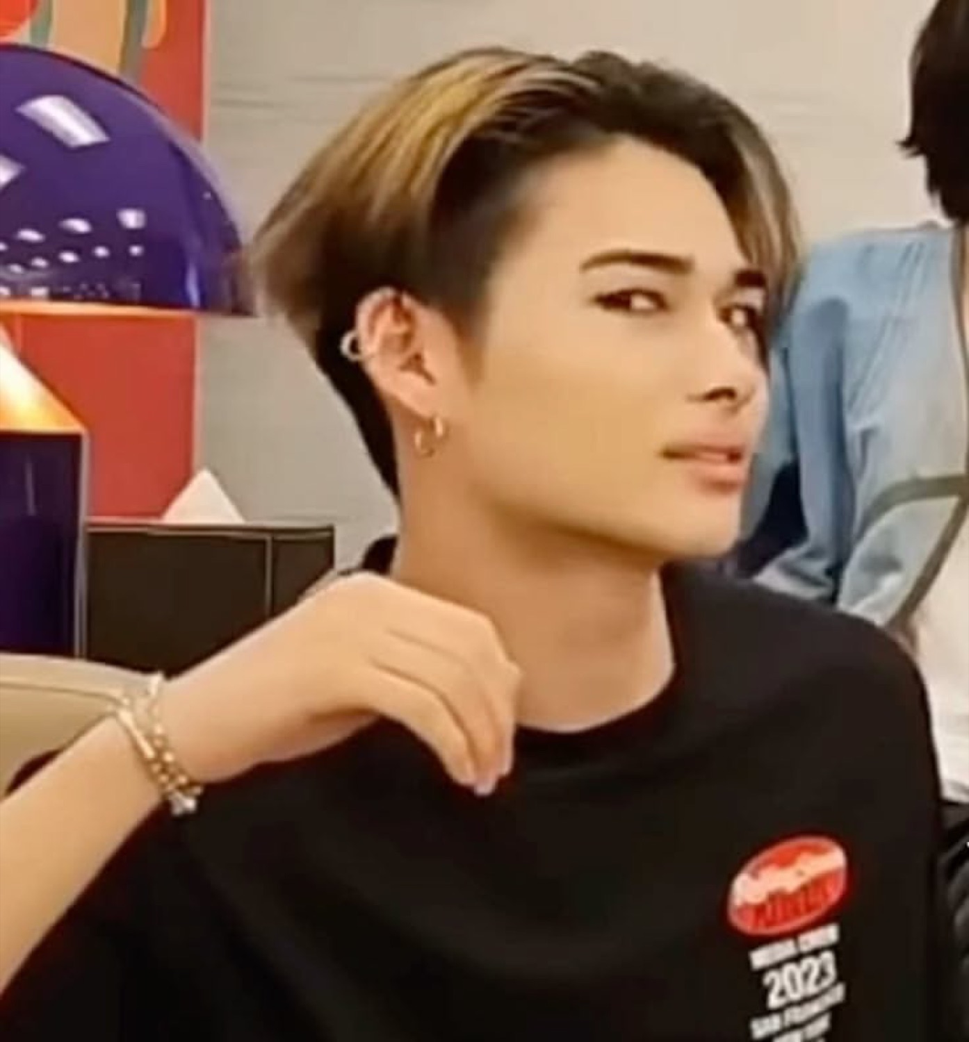 Person with a sleek undercut turning to deliver a flawless, chin-up side-eye