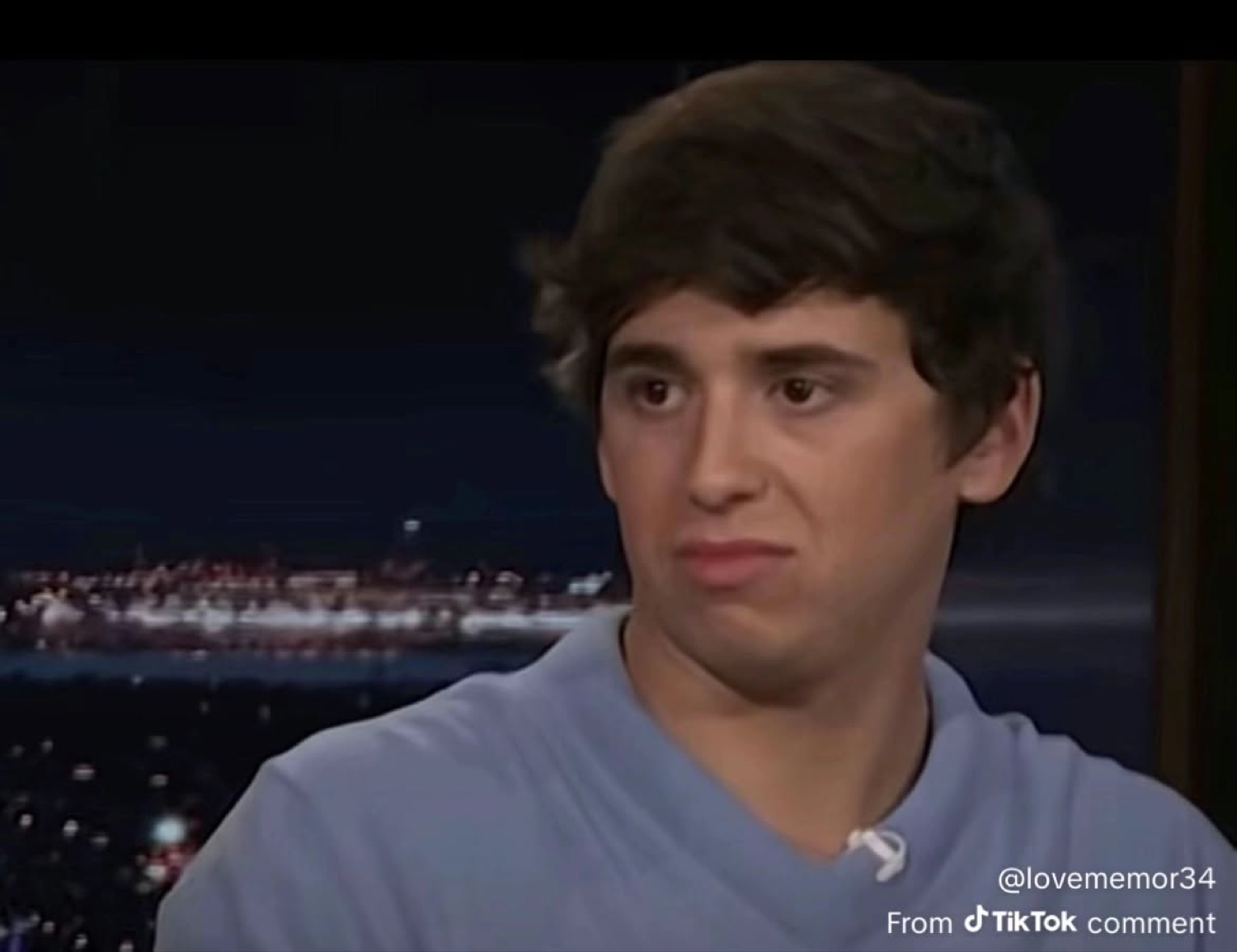 Young man on a talk show giving a flat, unimpressed sideways look