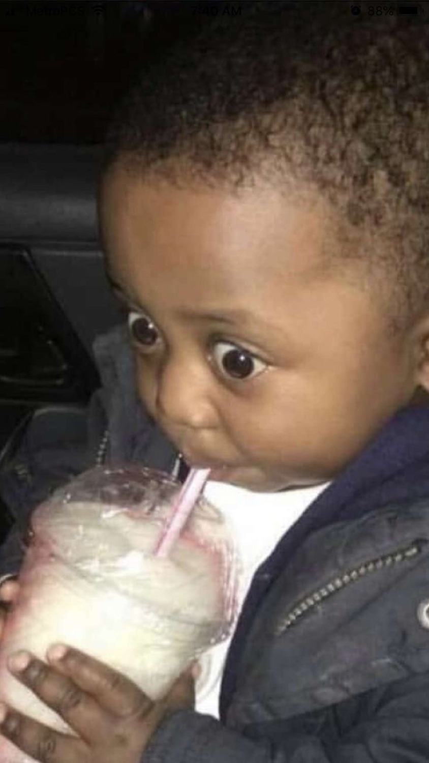 Toddler sipping a drink through a straw while giving a wide-eyed side-eye