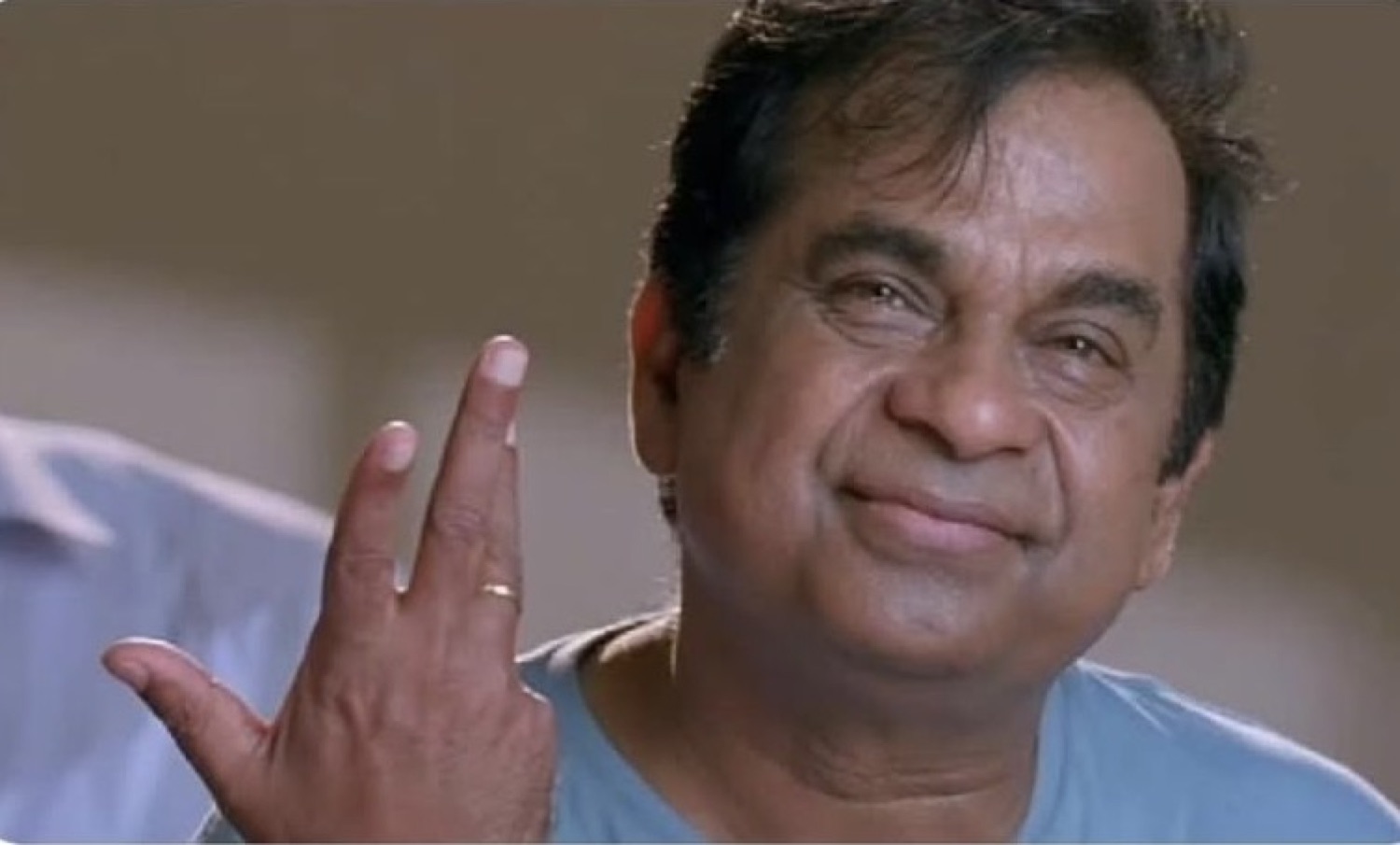 Brahmanandam waving with a smug little smile
