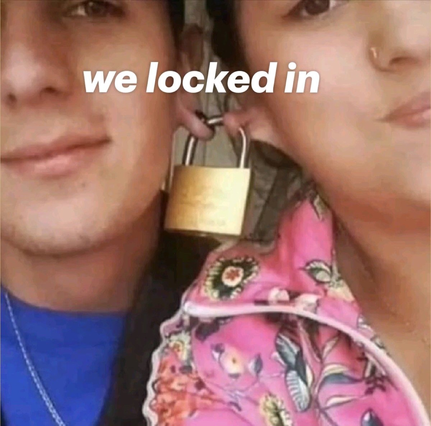 Couple pressed cheek to cheek holding a padlock between their teeth: 'we locked in'