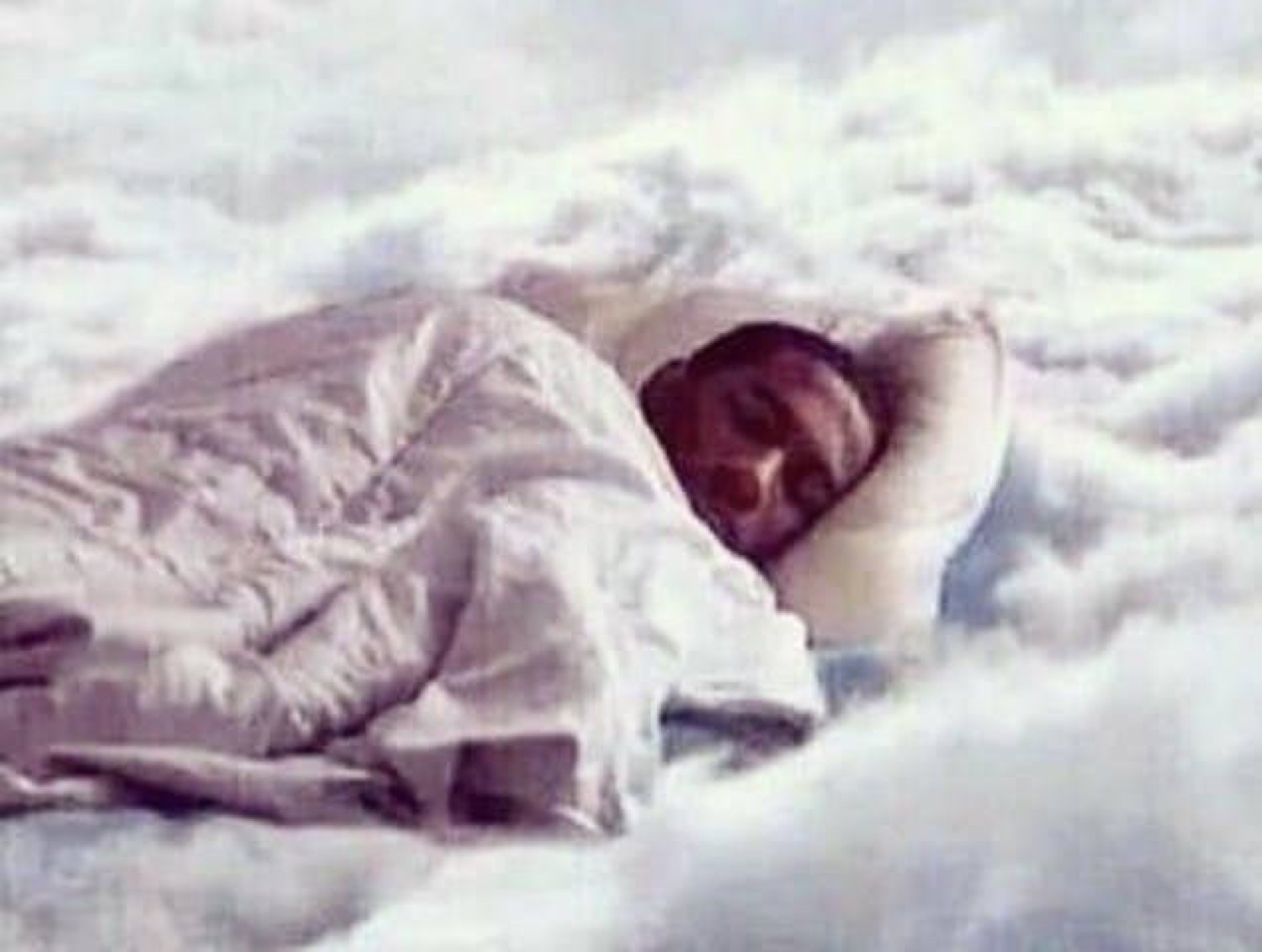 Person sleeping peacefully on a bed of clouds