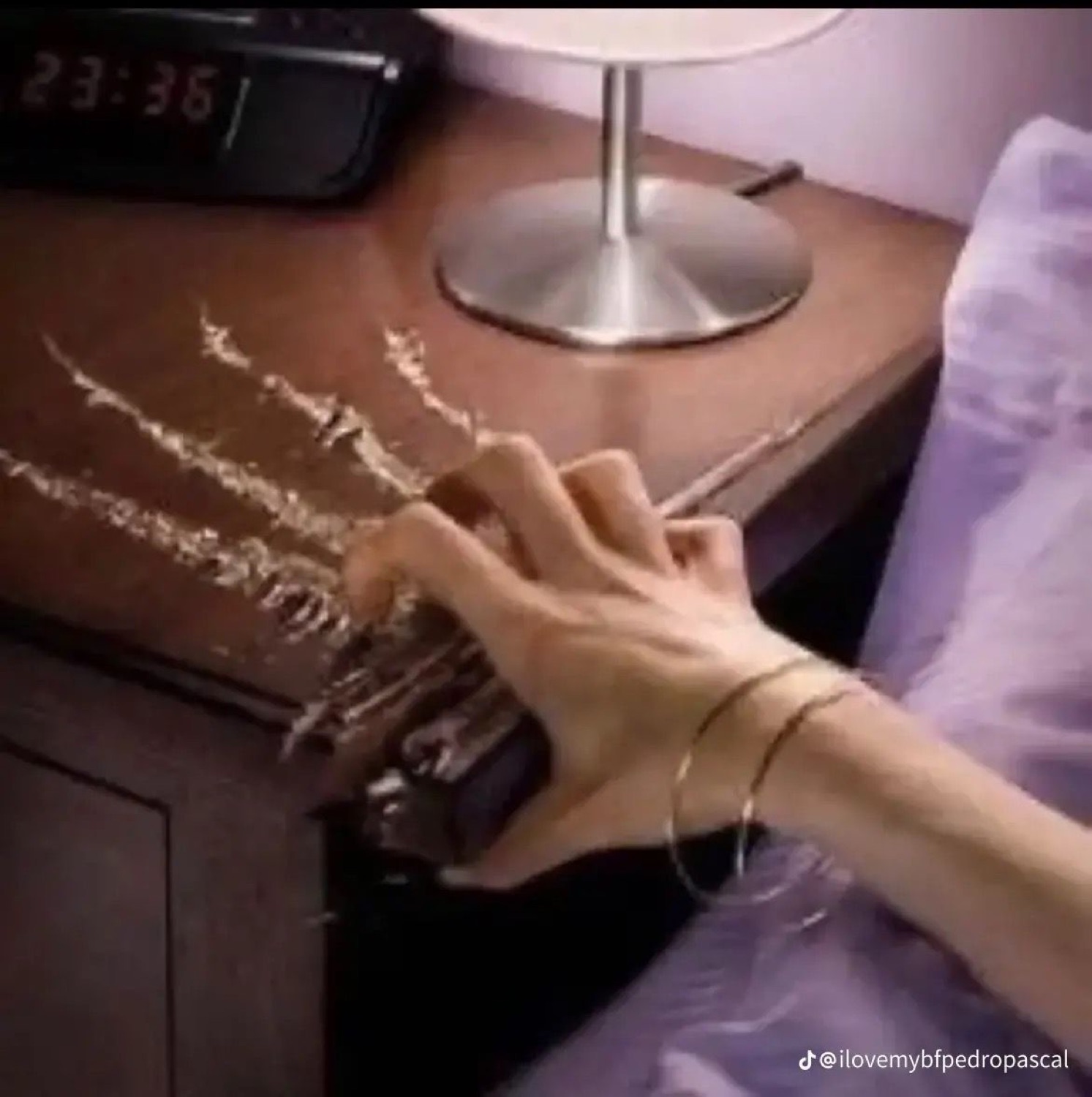 A hand slamming an alarm clock at 23:36, scratching deep claw marks into the nightstand