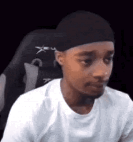 Man in a durag in a gaming chair turning with a stunned look