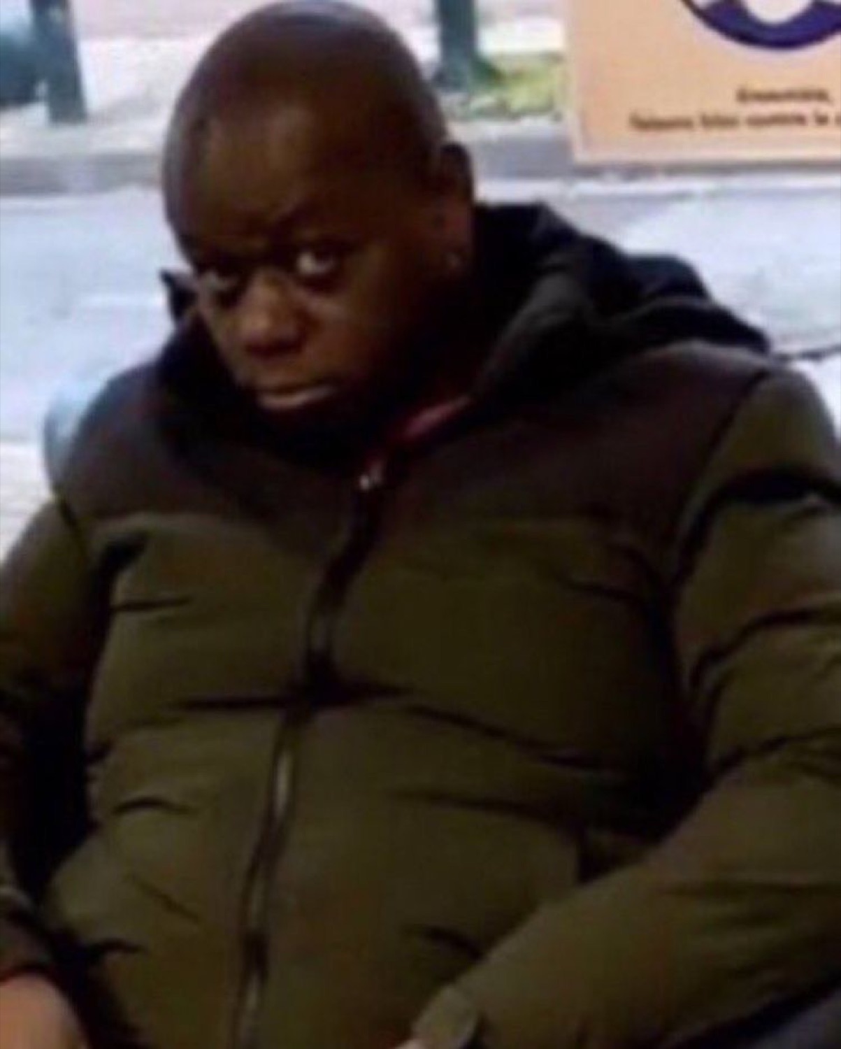 Man in a green puffer jacket throwing a slow, unimpressed side-eye