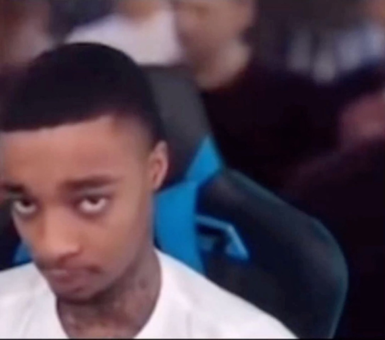 Guy in a gaming chair cutting a slow, heavy side-eye at the camera