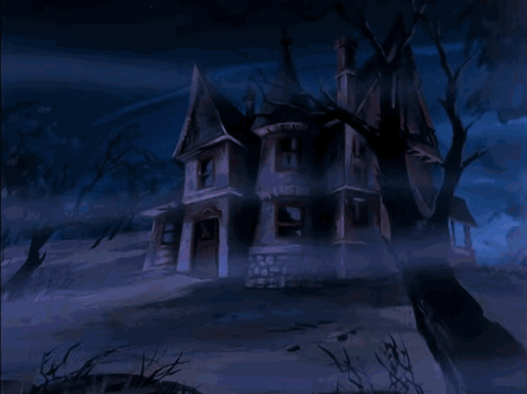 Haunted mansion on a hill at night under a blue sky