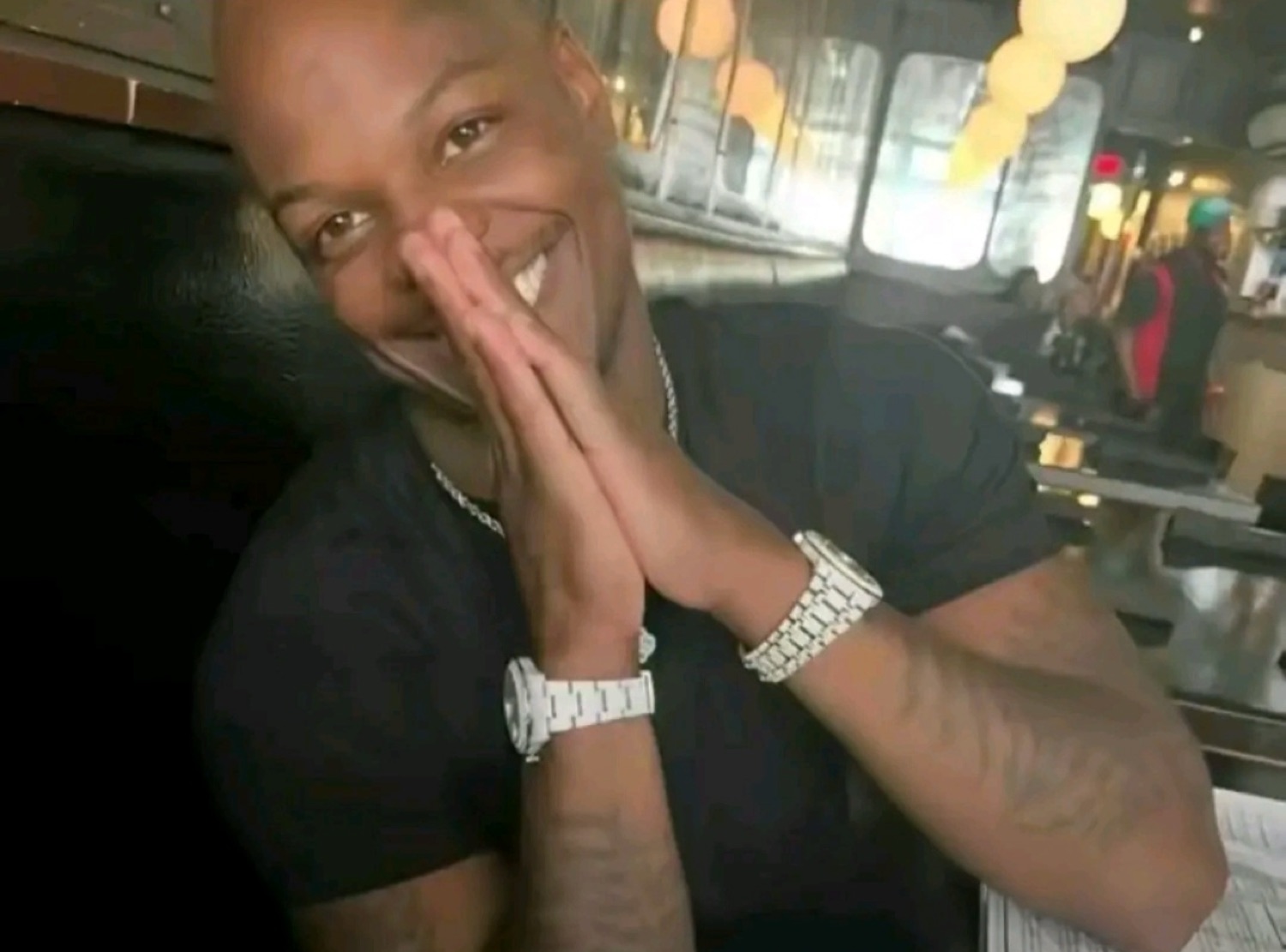 Man with hands pressed together grinning gratefully