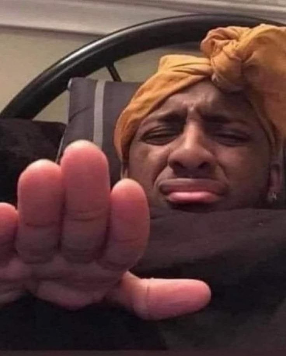 Man under a blanket holding his hand out to say stop