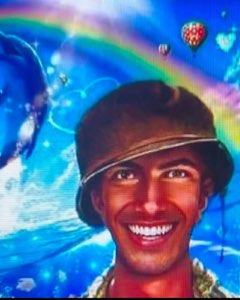 Man in a bucket hat beaming in front of an edited rainbow-and-dolphins backdrop