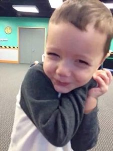 Toddler tilting head with a shy, charming little smile