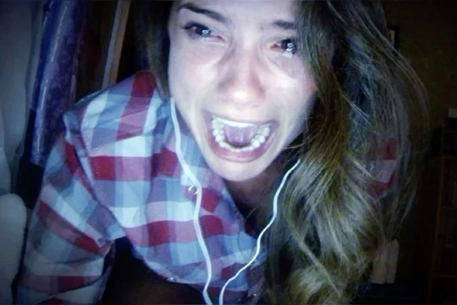 Woman on a webcam screaming in tearful terror at whatever she's watching