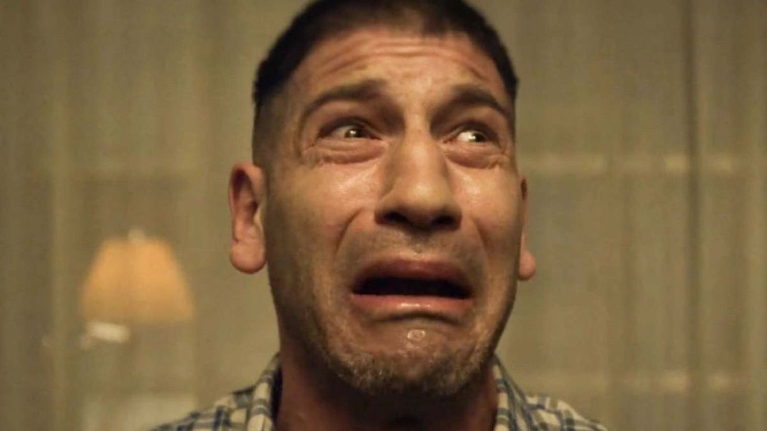 Man with a trembling, tear-streaked face looking up while on the verge of ugly crying