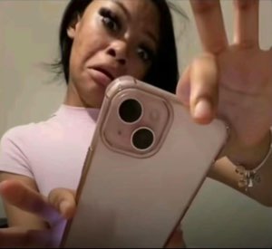 Mirror selfie of a woman holding her phone up with a tired, over-it expression