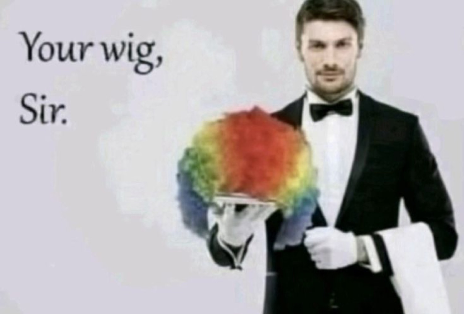 Deadpan butler presenting a rainbow clown wig on a silver tray, captioned 'Your wig, Sir.'