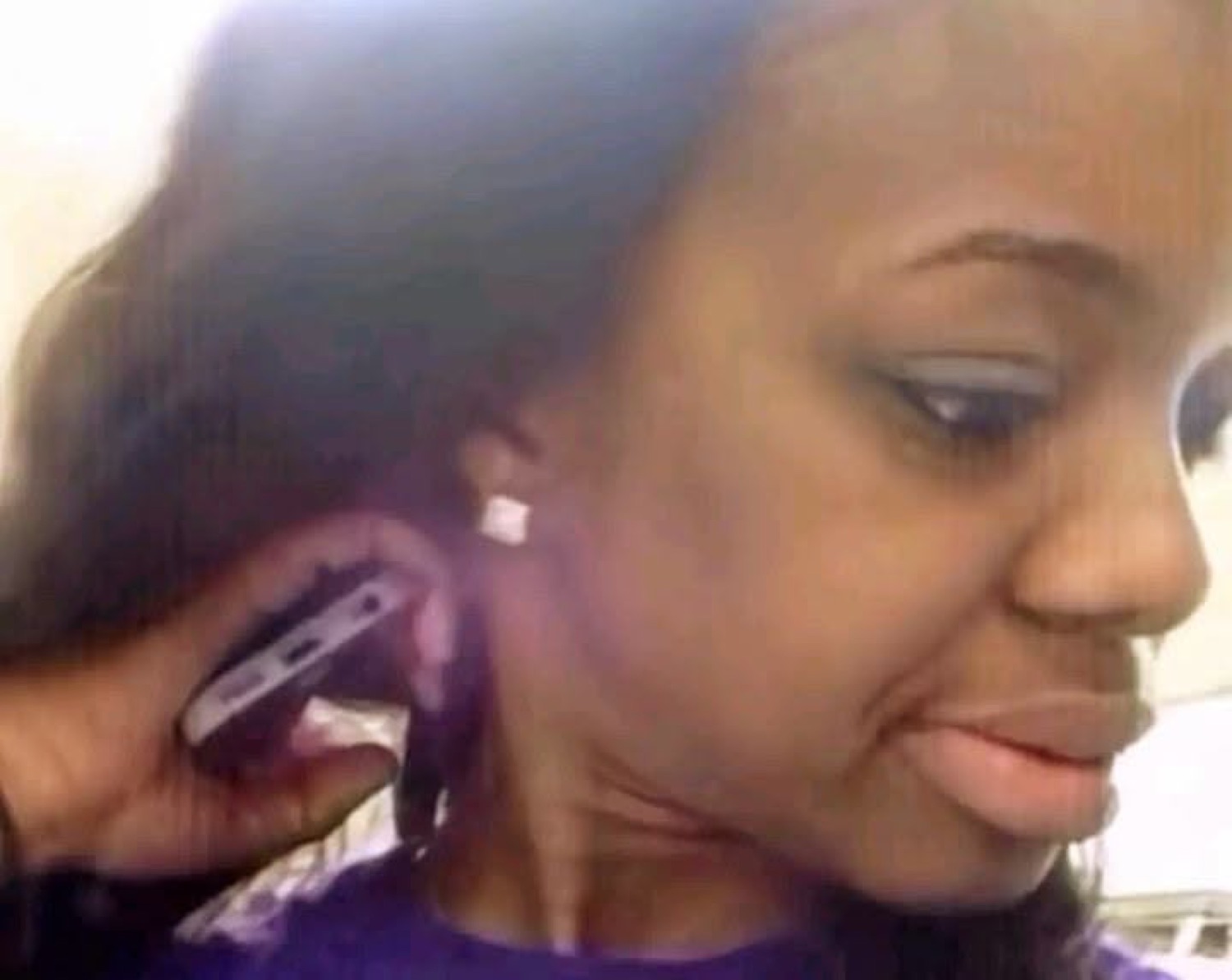 Woman holding a phone to her ear giving a cool, unbothered side glance