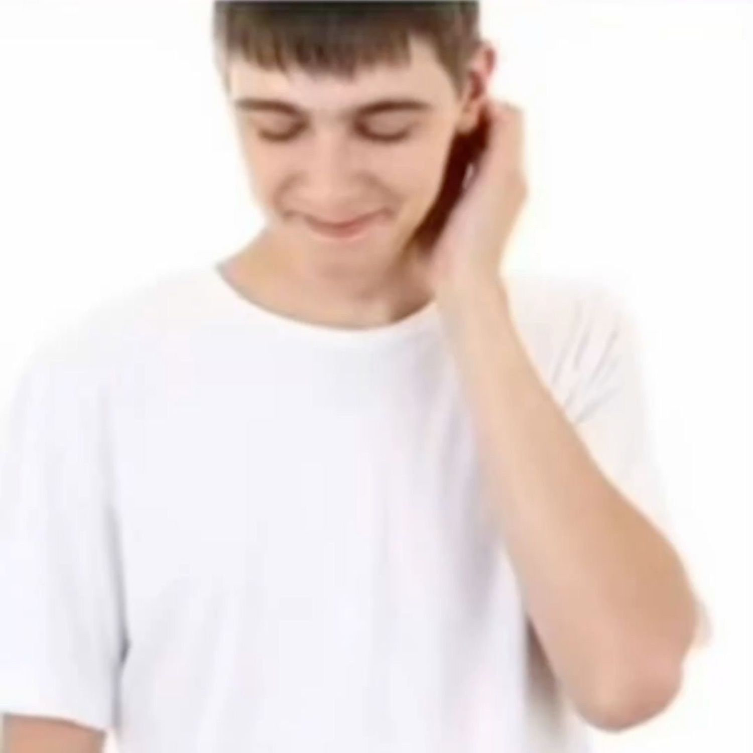 Young guy in a white tee looking down and shyly scratching his neck with a bashful smile