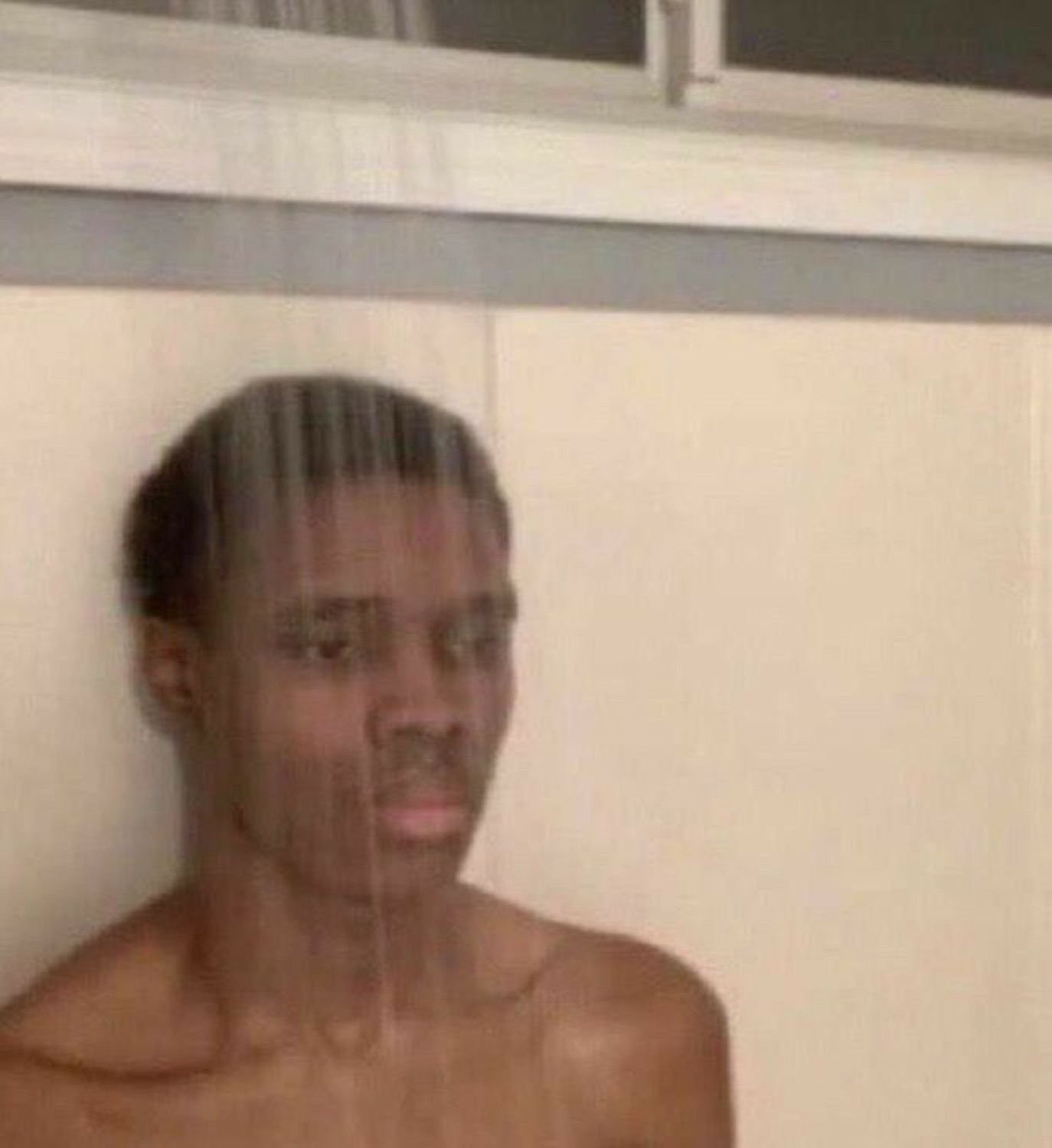 Young man standing behind shower glass with a completely blank, thousand-yard stare