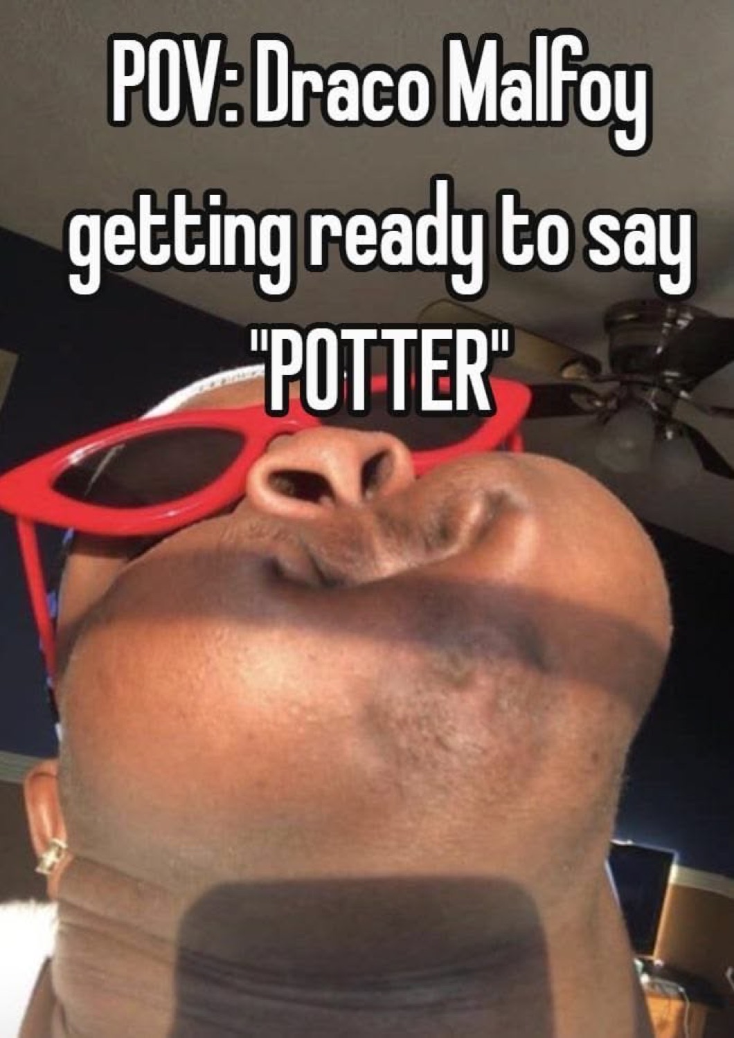 Man in red sunglasses pursing his lips from a low angle under 'POV: Draco Malfoy getting ready to say "POTTER"'