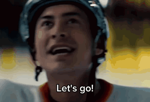 shane hollander player in a helmet grinning on the ice, "Let's go!"