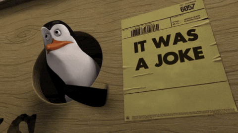 Madagascar penguin holding up a sign, "It was a joke"