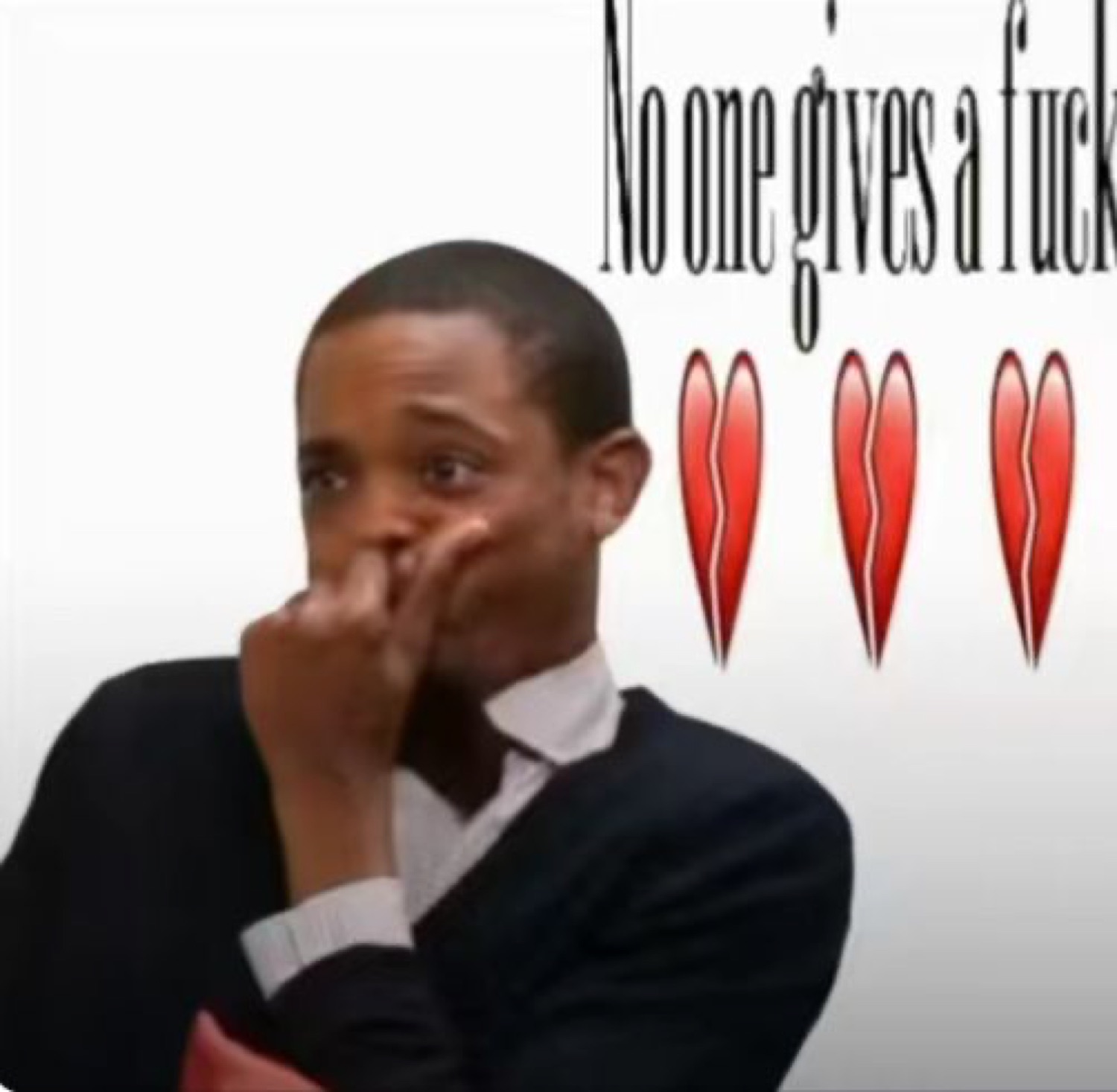 Man wiping his nose looking defeated next to 'No one gives a fuck' and broken hearts