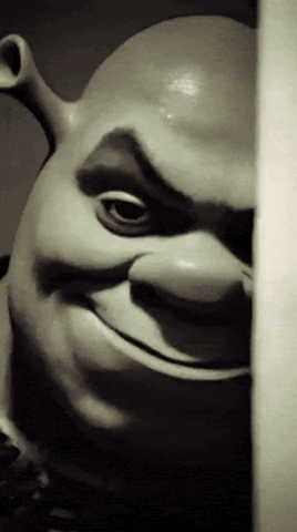 Shrek peeking from behind a wall with a creepy smile