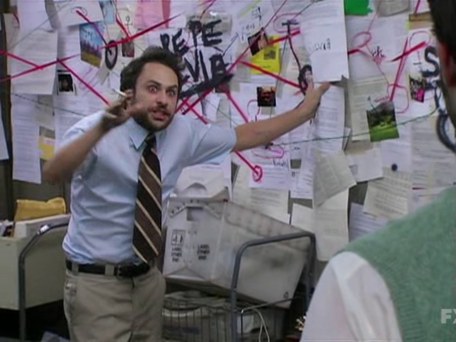 Frantic man in shirt and tie ranting in front of a chaotic conspiracy board