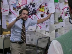 Frantic man in shirt and tie ranting in front of a chaotic conspiracy board